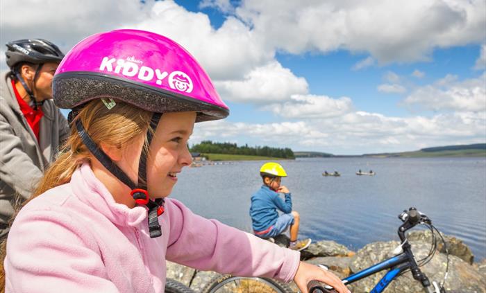 Family pausing to enjoy view over lake Llyn Brenig Cycling Conwy